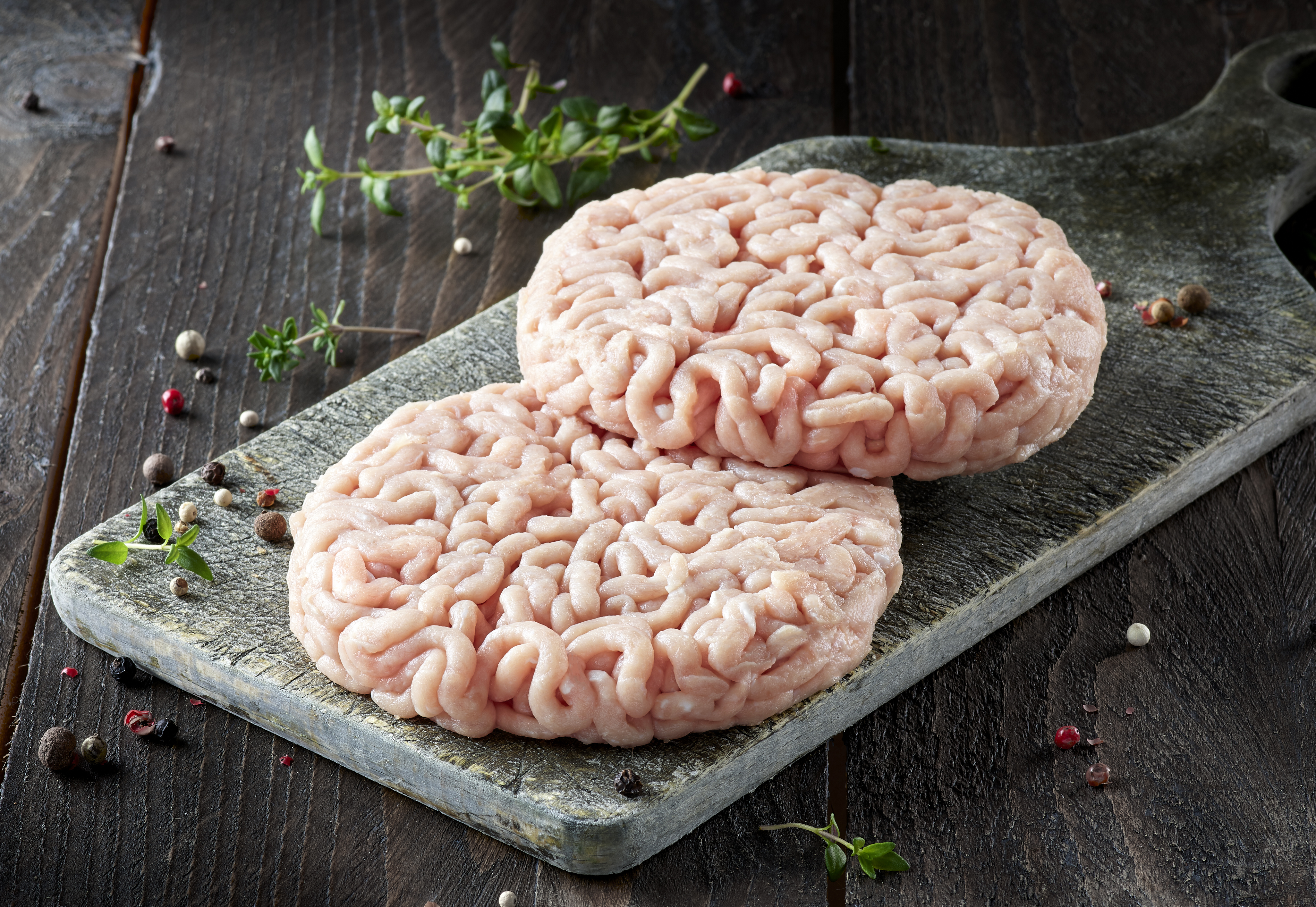 Doux traditional style chicken burger on a stone appetiser board on a dark wooden table